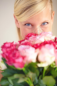 一位年轻女子的肖像在一束粉红色玫瑰上观看 (笑声) 我很高兴你做到了图片