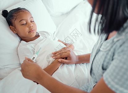 生病的小女孩躺在床上 她的母亲用温度计测量她的体温 年轻的单亲父母在她睡觉时坐在生病的孩子身边 小孩子生病时她的母亲图片