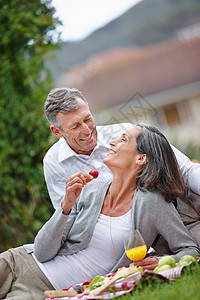 保持浪漫的活力 一个可爱的成熟夫妇 在草地上进行浪漫野餐图片