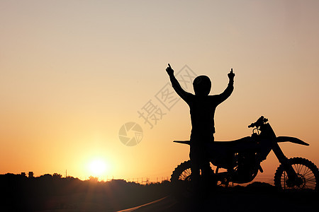 摩托车 剪影和日落 一名运动员在户外举起双臂 用模型庆祝自由 天空 自然和摩托车 男骑手在外面庆祝公路旅行图片