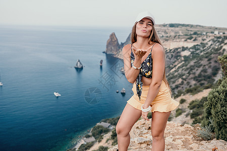 女人出海 快乐的游客在户外拍照留念 女旅行者望着山湾的悬崖边 分享旅行冒险之旅女士自由海洋风景女孩旅游自拍闲暇假期远足图片