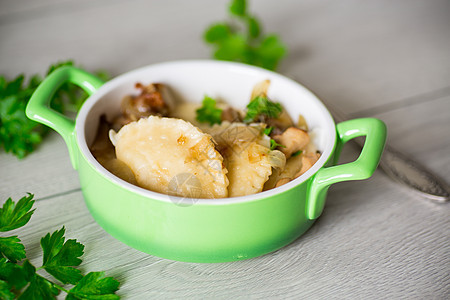 盘子里有洋葱和蘑菇的马铃薯子桌子面团陶瓷制品奶油厨房抛光美食饺子糕点图片