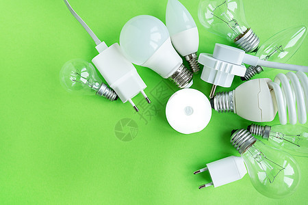 一组不同类型的 LED 灯隔离在绿色背景上 节能灯 在中央打开手电筒图片