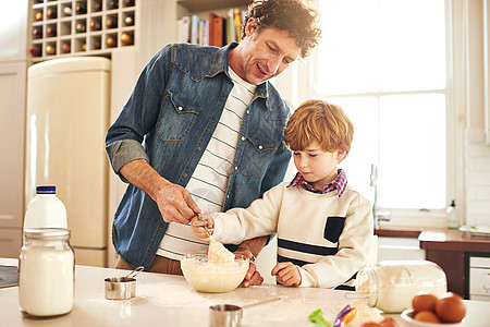 帮他的小面包师 一个父亲和儿子在家一起烘烤图片