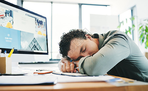 小睡对提高工作效率至关重要 一个年轻的商务人士在办公室打盹图片