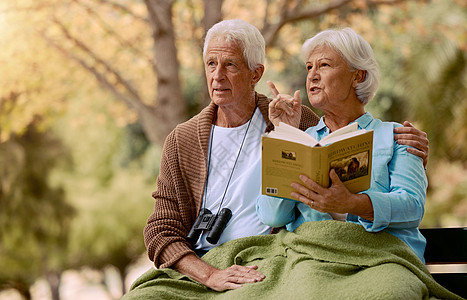 一对年长的夫妇在大自然中一起坐在公园的长椅上观鸟 读书和双筒望远镜 森林 爱情和退休 与一对成熟的男人和女人在花园里放松 欣赏夏图片