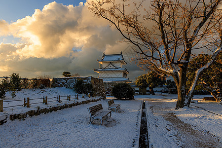 日出光照耀着古老的日本城堡 在寒雪的冬天清晨图片