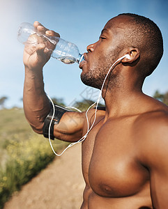 那个锻炼让我很渴 一个年轻男人在运动时喝着一瓶水 喝着酒图片