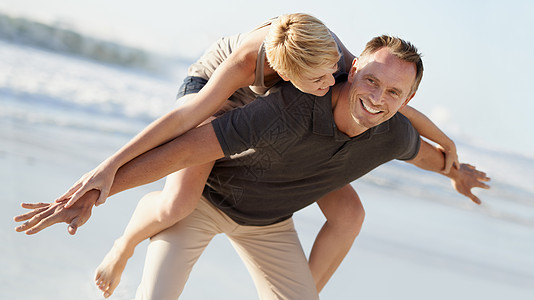 一个丈夫在海滩上搭便车送妻子去海边玩耍 这是很好的关系的秘诀图片