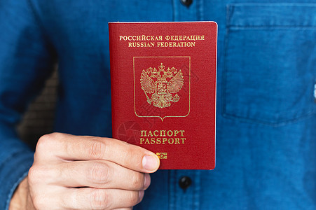 一个男人手拿着外国护照的衬衫的特写 准备度假的概念鉴别国籍旅游移民男性旅行国家公民节目文档图片