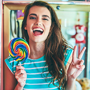 一位有魅力的年轻女子在旧餐店吃巨型棒棒糖 她被刻画成肖像图片