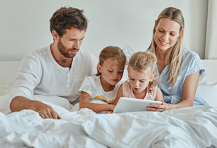 平板电脑 电影和卧室里的家人在网上播放可爱的系列订阅 并在一个慵懒的早晨放松 母亲 父亲和孩子们在周末看电视以建立联系和娱乐图片