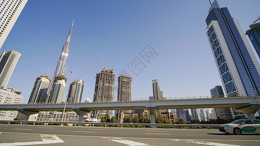 在阳光明媚的一天 迪拜高塔和现代摩天大楼街道市中心天线酒店建筑运输地标玻璃天空天际图片