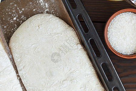 用于在烤盘上烘烤面包的新鲜生面团 准备在木质背景上烘烤 特写馅饼面粉别针包子桌子木板服务美食小麦食谱图片
