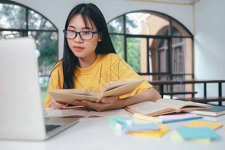 年轻的亚洲女学生正准备读一本大学考试的书 笑声自学知识校园技术阅读中学测试学生互联网写作图片