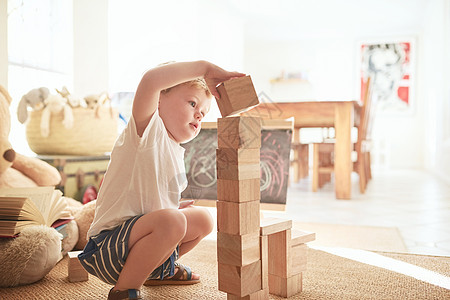 一个可爱的小男孩 在家里玩木头砖块的游戏 - 是啊图片