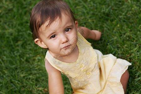 一个甜美的小女孩坐在草坪上 在镜头前笑着笑起来 那时她坐在草坪上图片