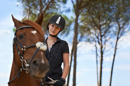 在马背上体验大自然 一位年轻女子骑着她的栗色马去兜风训练成人板栗马匹马术缰绳骑马女性动物女士图片