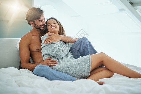 让我们分享一些体温 一个情深的年轻夫妇在床上 分享亲密的时光图片