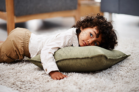 这是我最喜欢的观影姿势 一个可爱的小男孩躺在地毯上 在家看电视图片