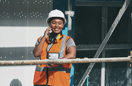 新版本一切顺利 一名年轻女子在建筑工地工作时正在打电话图片