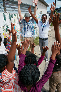 好的 大家举手 志愿工作者在社区外展活动中向一群儿童讲话图片