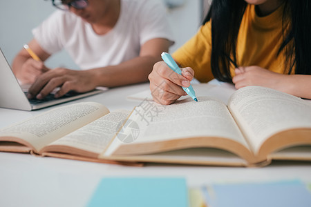 近身的亚裔学生正在阅读书本和学习 并一起教学朋友们课堂电脑智力家庭作业咨询学费愿望讨论校园图片