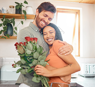 年轻满足的白人男友在家里给了她一束鲜花后拥抱了他的混血女友 西班牙裔妻子从丈夫那里收到玫瑰花 跨种族夫妇结合在一起图片