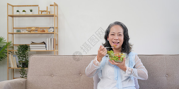 在家里吃健康蔬菜沙拉的快乐老妇人厨房早餐夫妻祖母房子饮食老年乐趣退休女性图片