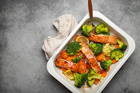 在灰石背景的砂锅菜中 可以看到健康的烤鱼鲑鱼排 西兰花 花椰菜 胡萝卜 烹饪美味的低碳水化合物晚餐 健康的营养理念 文字空间沙锅图片