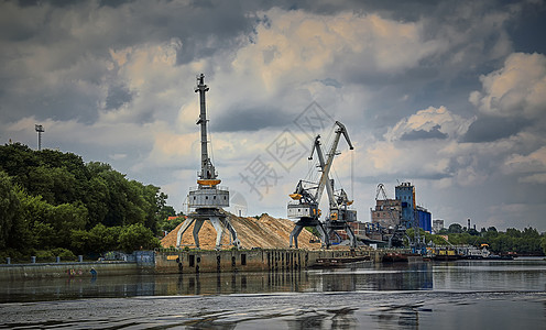 夏季的河港 河岸边的港口起重机 河港的堤防 在码头墙上的一艘驳船后勤运输城市蓝色海船旅行加载货物出口船运图片
