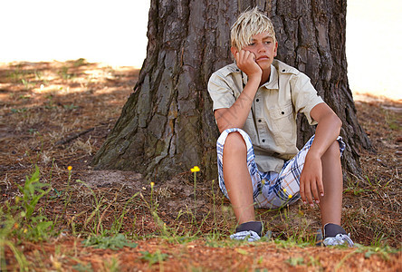 夏令营烂透了 一个小男孩坐在树下看着一个无聊的表情图片