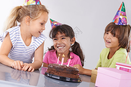 三个朋友在生日派对上笑着 在他们面前拿个蛋糕来笑 我和他一起吃蛋糕图片