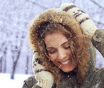 爱第一场雪 一个迷人的女人 在雪中享受着外表的乐趣衣服女性幸福黑发毛皮微笑天气兜帽裁剪成人图片