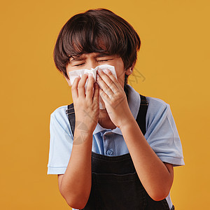 一个混血亚裔男孩在看病时抽鼻涕 并假冒橙色复制空间背景 可爱的亚洲孩子流鼻涕和过敏图片