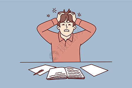 愤怒的男子用工作手册把头抱在桌子上 因为神经紧张的工作受苦图片