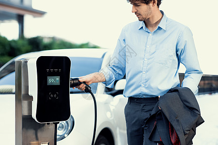 进化商务人士从充电站到EV的插座充电器插头电池力量生态技术电动车充电站住宅城市商务人士图片