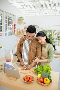 根据平板电脑上的食谱 一起烹饪的一对漂亮的年轻夫妇的肖像饮食厨房女性男性夫妻成人食物女士男人乐趣图片