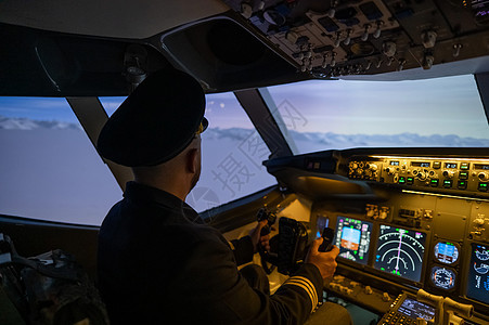一个人正在学习如何在飞机模拟器中当飞行员图片
