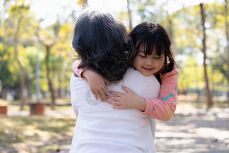 一个可爱的曾孙女抱抱 抱抱她奶奶 在公园玩得开心 很亲切图片