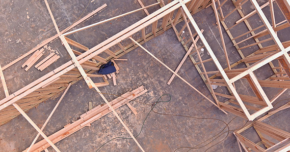 正在建造木材框架房 木梁框架在棍棒盖房屋上方; 在建筑中图片