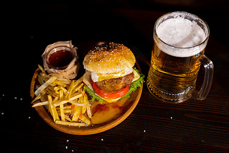 一套汉堡啤酒和炸薯条 酒馆里一套标准的饮料和食物 啤酒和小吃 黑暗的背景 快餐 传统的美国食物餐厅盘子桌子午餐美食包子酒吧面包土图片
