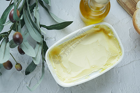 桌子上的容器里撒满橄榄油的橄榄黄油图片