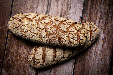 棕色背景的黑麦面包木板糕点烘烤厨房桌子乡村木头早餐大麦食物图片