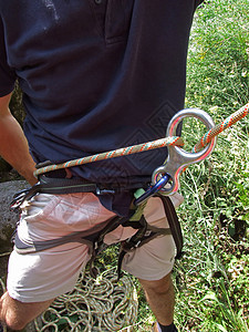 一名登山者保护另一名登山者胜利成人力量风险绳索悬崖岩石男人勇气蓝色图片