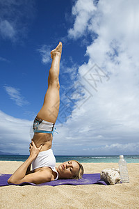 女人在海滩上做瑜伽身体素质金发女士闲暇支撑身体平衡热带海岸照片图片