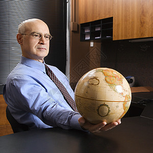 商务人士掌握着全球男性男人生长工作职业照片桌子办公室地球全世界背景图片