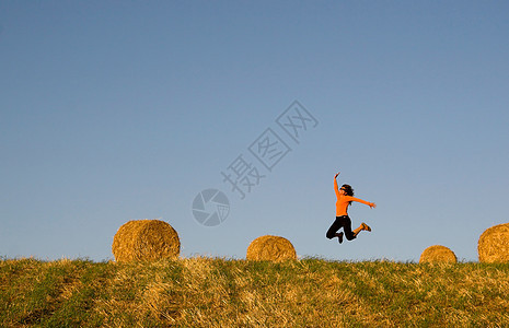 女人在干草篮田中跳跃太阳灵魂温泉女士时间阳光女孩们身体乐趣天空图片