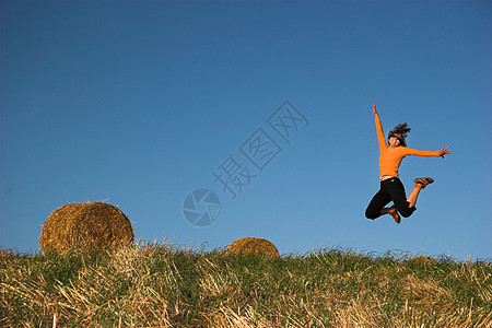女人在干草篮田中跳跃灵魂女士乐趣阳光场地女孩们运动天空活力身体图片