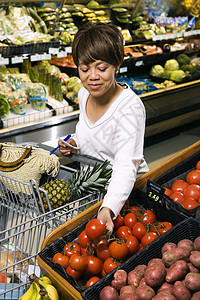 妇女杂货店购物检查杂货车蔬菜照片走道商品中年女性店铺购物车图片